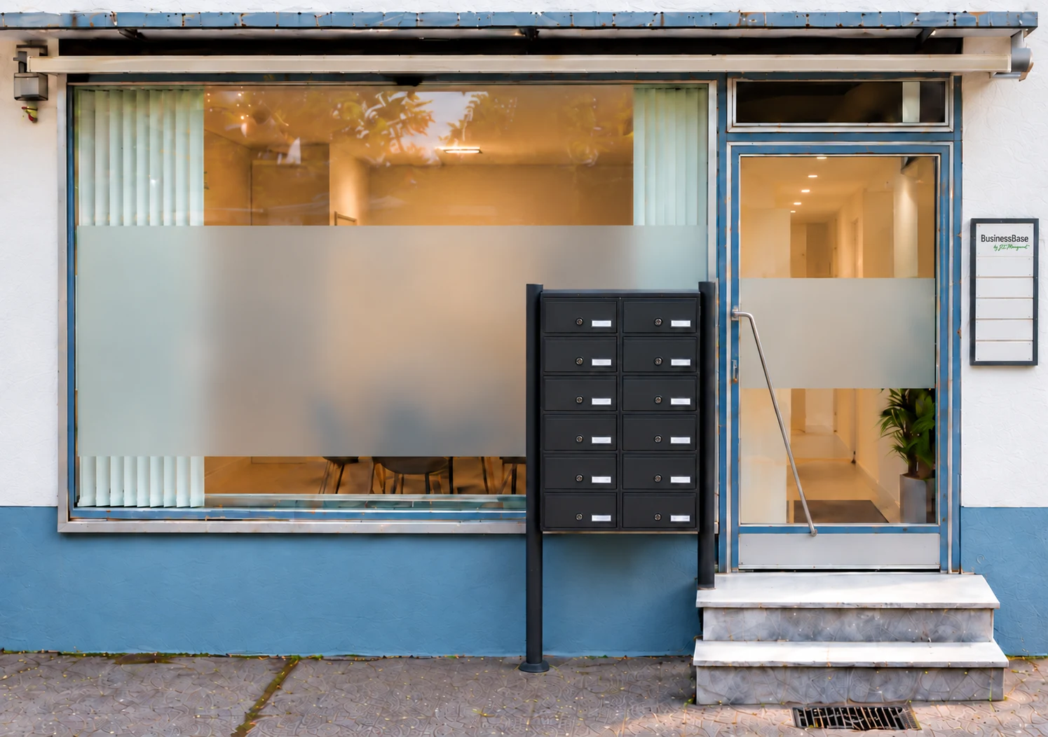 BusinessBase: großes Schaufenster, Eingang rechts daneben mit Milchglasstreifen und Stufen davor